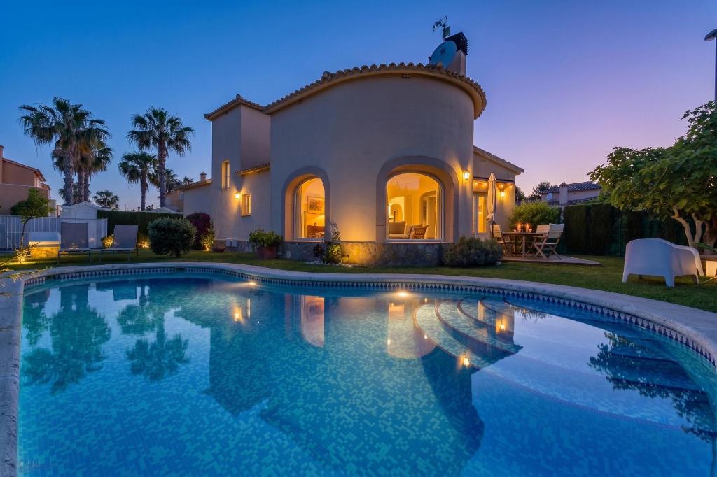 a large swimming pool in front of a house at Villa Oliva Nova - Private Pool in Casas Devesa