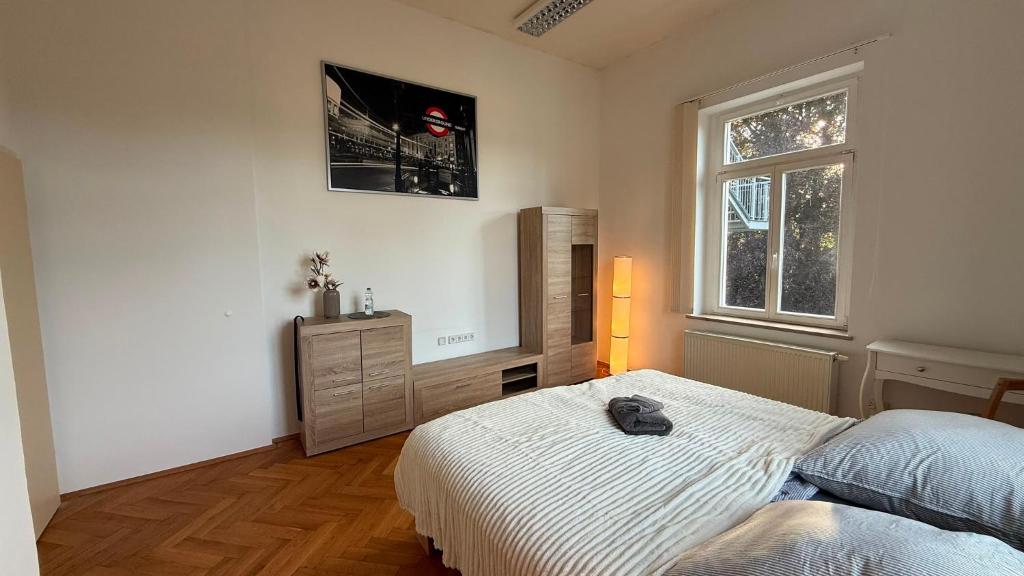 a bedroom with a bed and a dresser and a window at MartiniRoom Signature in Glauchau