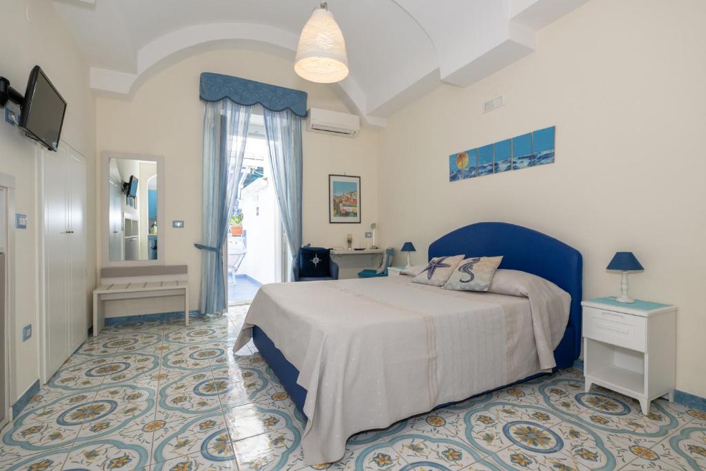 a bedroom with a bed with a blue headboard at Libeccio - flat with terrace and sea view, perfect for up to 3 guests in Maiori
