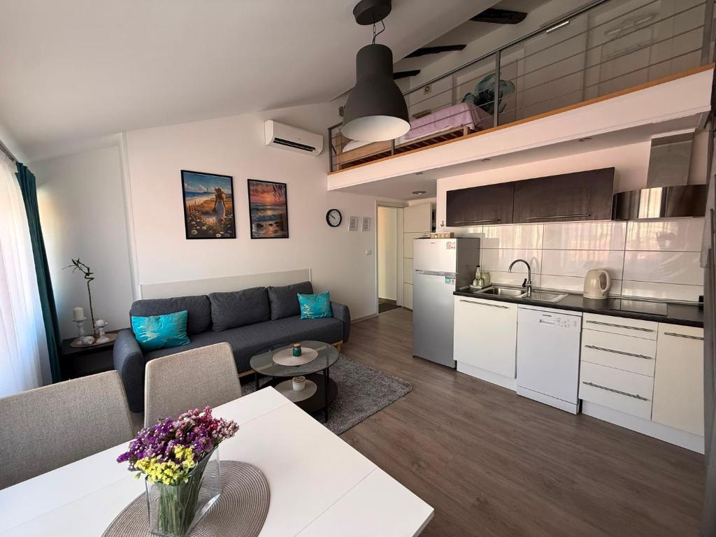 a kitchen and living room with a couch and a table at Downtown Apartments Pula in Pula