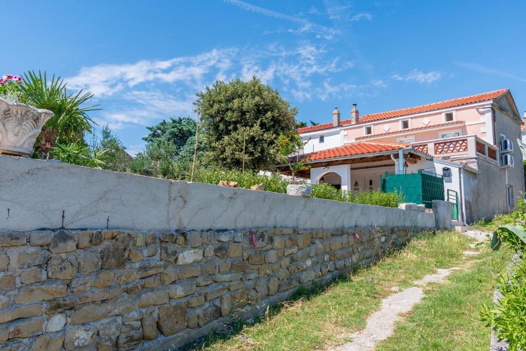 a stone wall in front of a house at House Vila Ana in Lopar