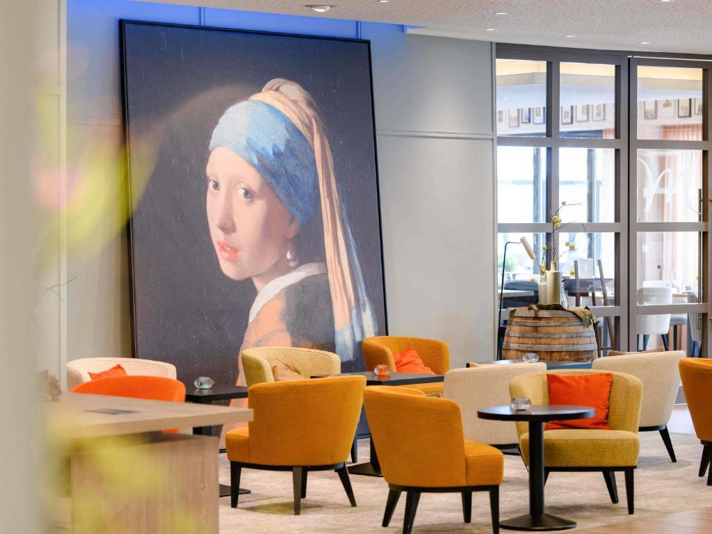 a large painting of a woman with a head at Mercure Hotel Saarbrücken City in Saarbrücken