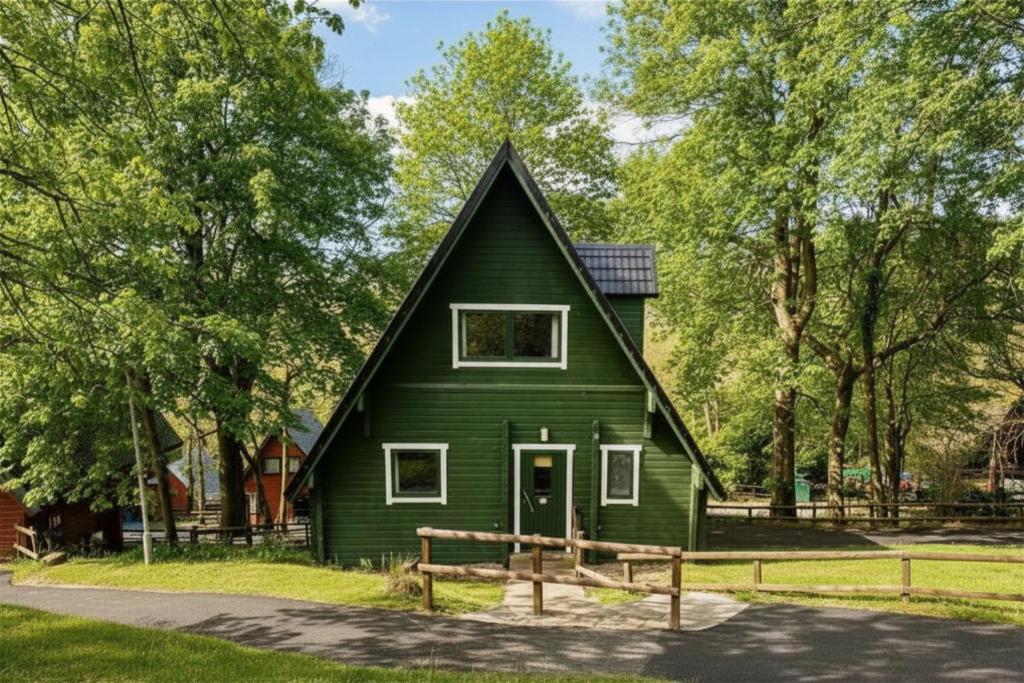 a green house with a gambrel roof at Tor View Lodge with Hot Tub & Sauna - Spa Resort - South Devon in Chudleigh