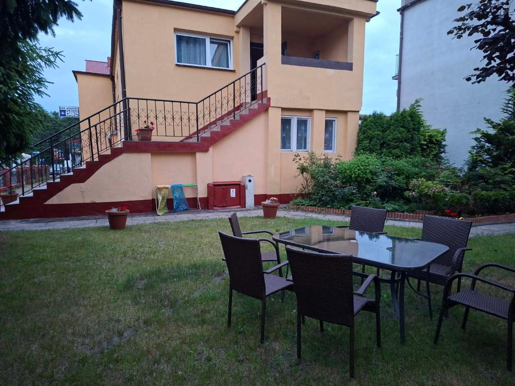 a table and chairs in front of a house at Dom Wczasowy Jędrek pokoje in Niechorze