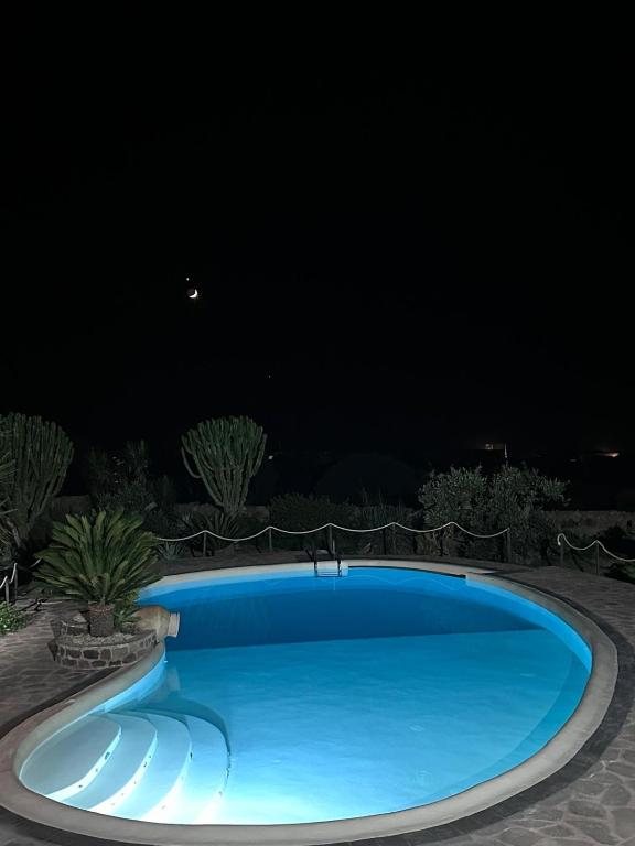 a large blue swimming pool at night at Dammuso Kazen Jezabel in Pantelleria
