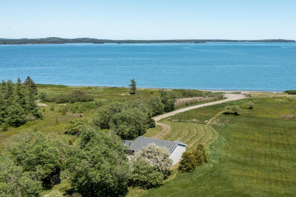 an aerial view of a house in a field next to the water at Seascape Serenity with Epic Coastal Views! in Lubec