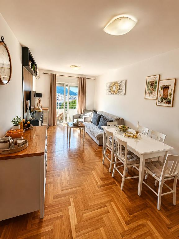 a kitchen and living room with a white table and chairs at SeaSideApartman3 in Budva