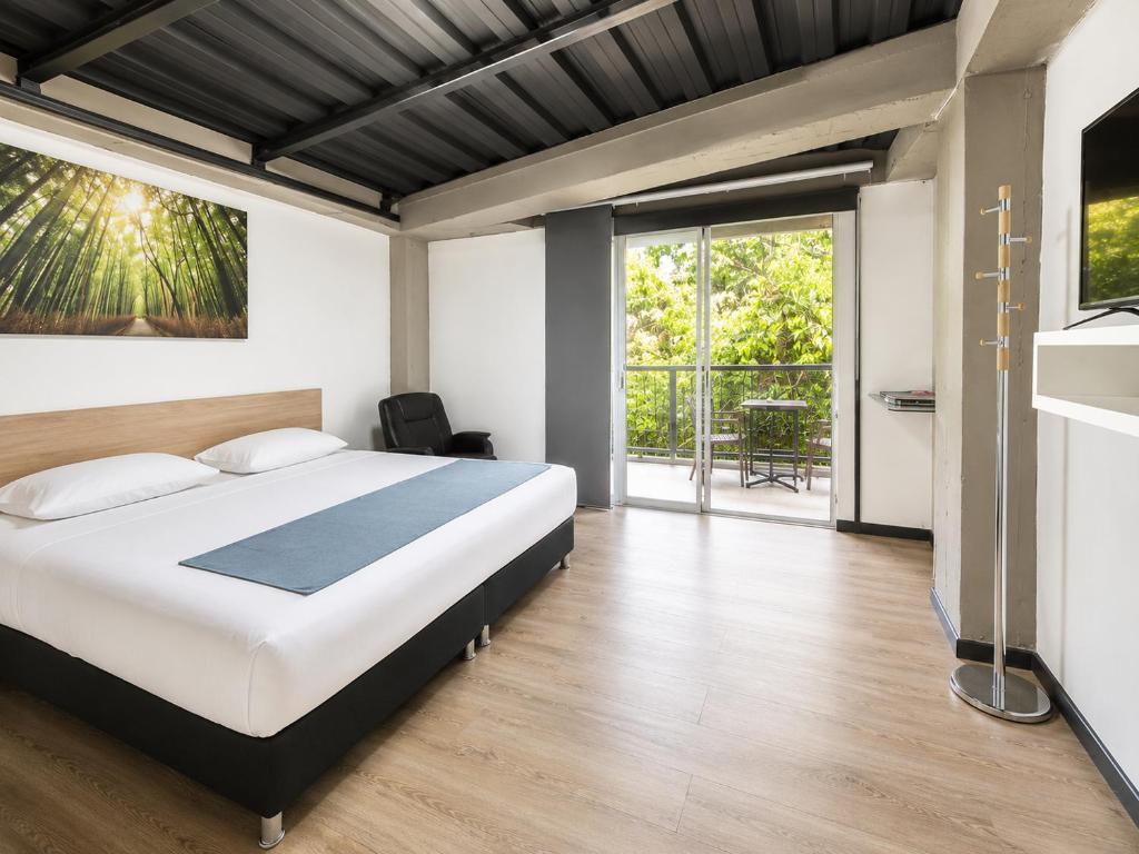a bedroom with a bed and a large window at Carriqui Garden Hotel in Pereira