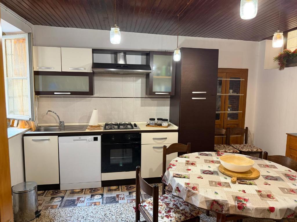 a kitchen with a table and a stove top oven at Casa Fulvia by Lago Maggiore Rentals & Estate in Cannobio