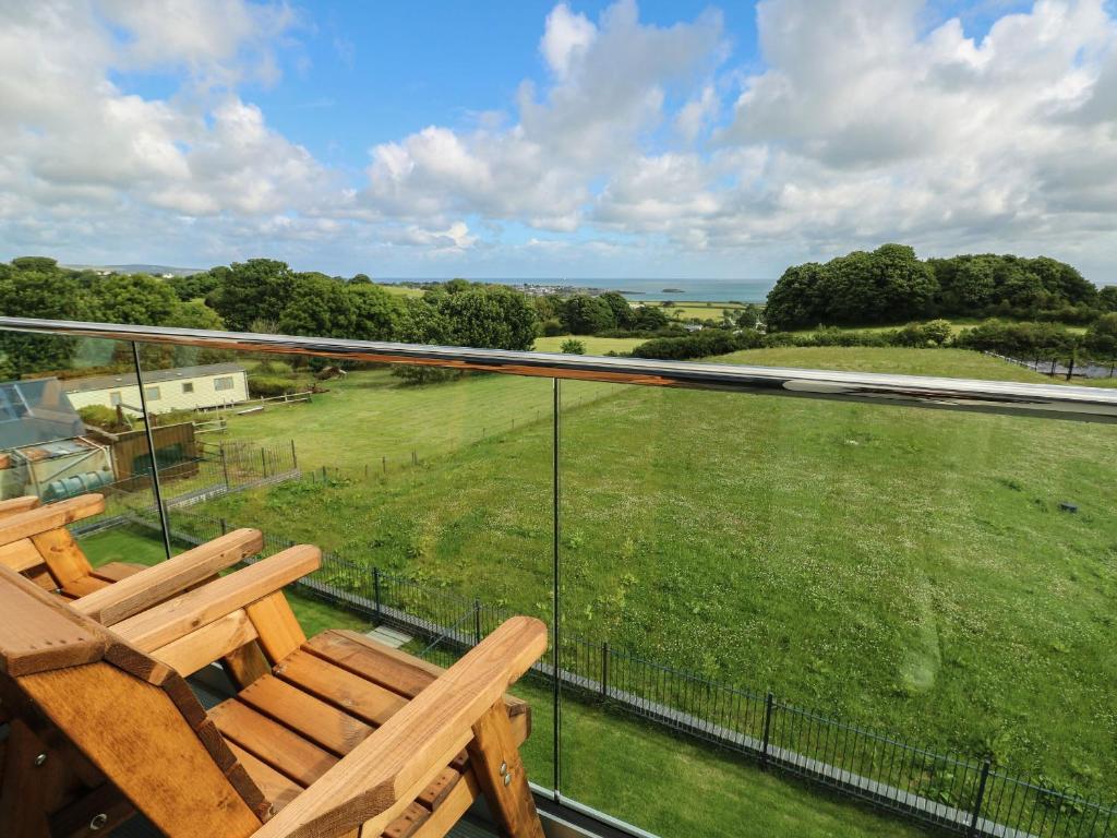 a balcony with a view of a green field at Glynllifon 9 in Llanallgo