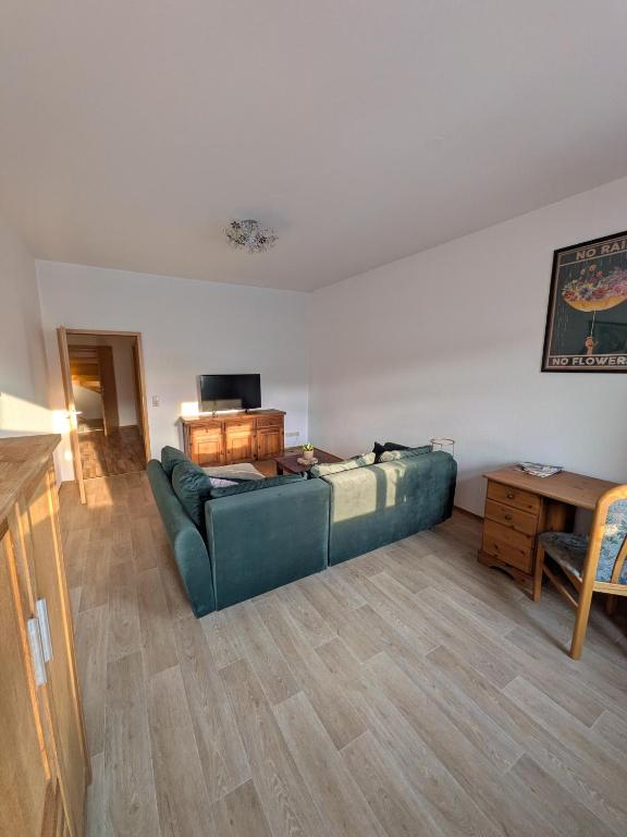 a living room with a green couch and a table at Marktblick in Radeburg