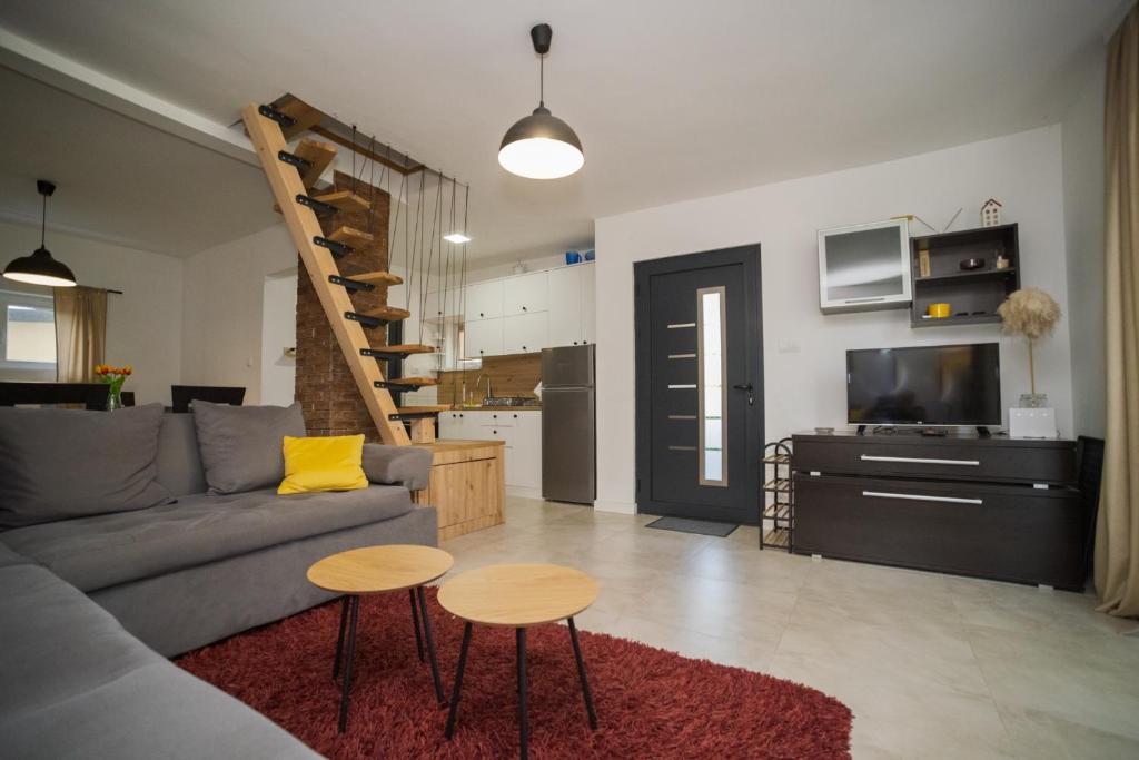 a living room with a couch and two tables and a tv at Vikendica Mir Čortanovci in Čortanovci