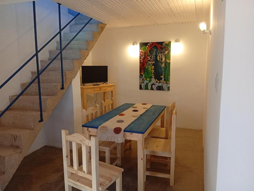 a table and chairs in a room with a staircase at Cabañas don Julio in Maimará