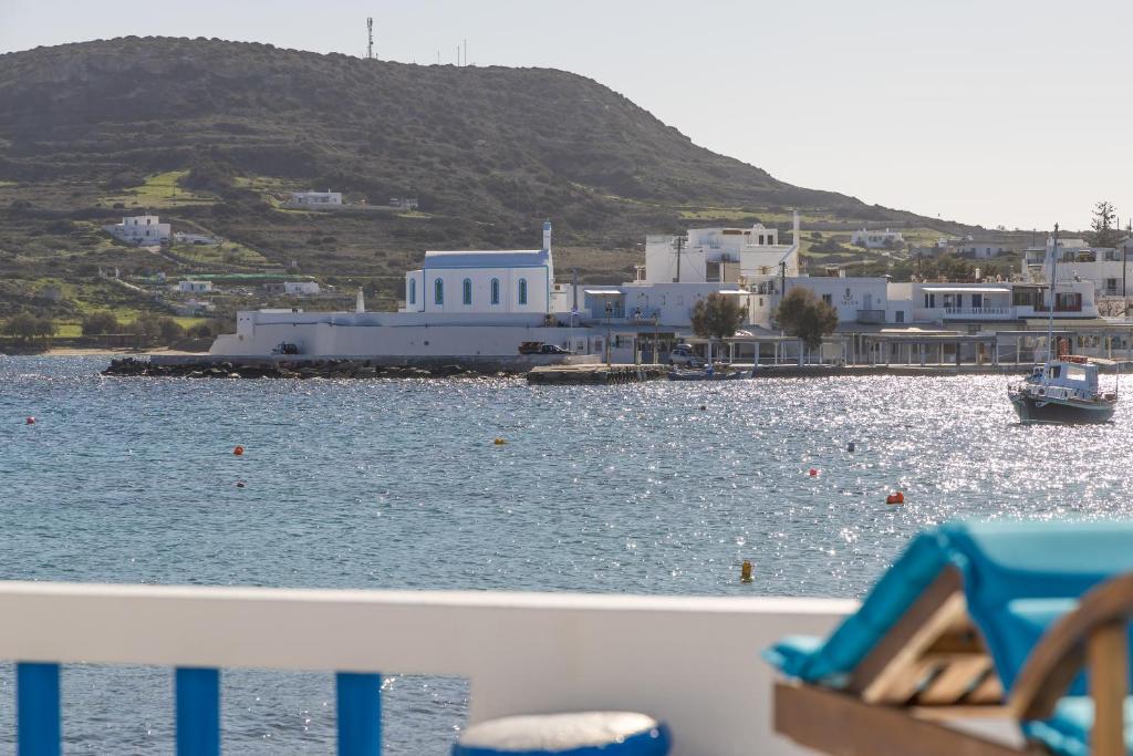 a boat in a body of water with buildings at Pera Milos villa in Pollonia