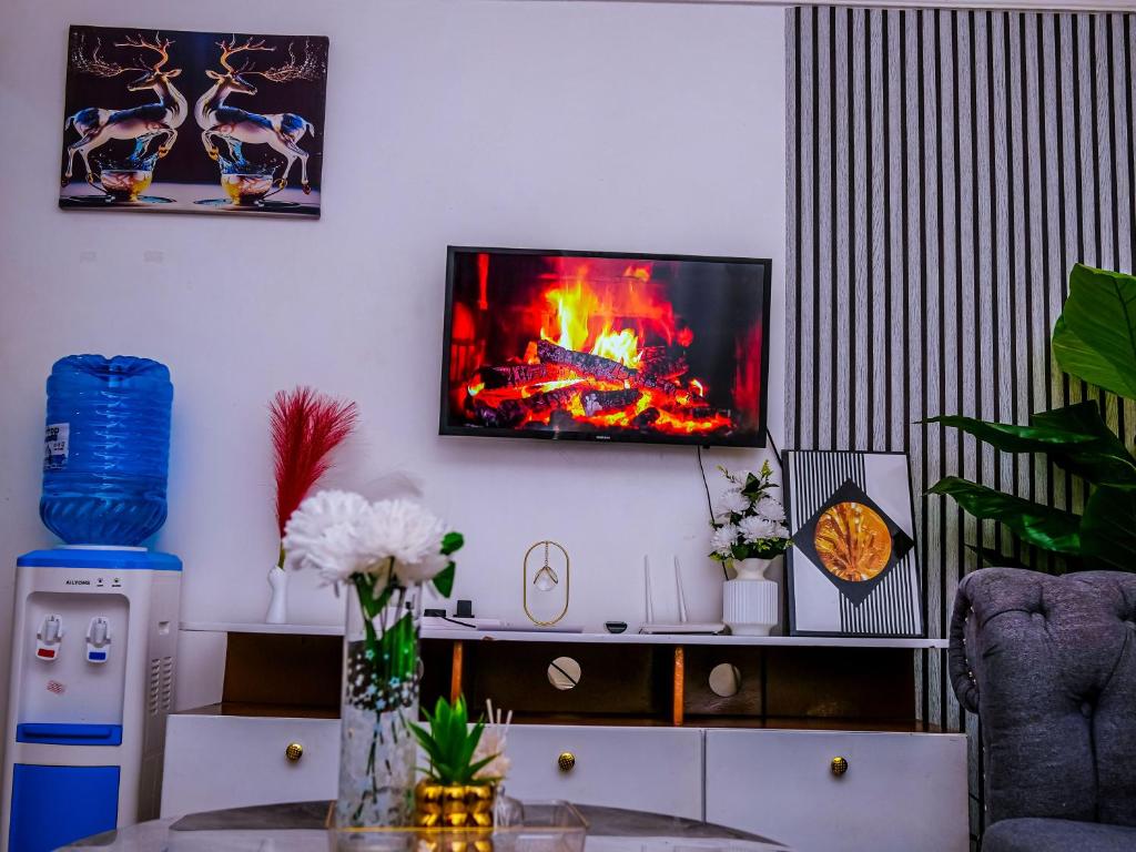 a living room with a fire on the wall at Homes By Vee in Eldoret