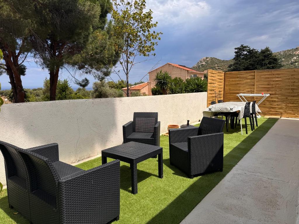a yard with chairs and a table and a fence at casa serena in Lumio