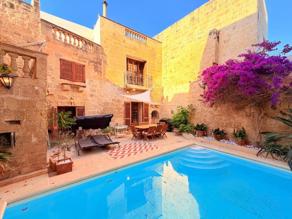 a courtyard with a swimming pool in a house at Charming 450-Year-Old House with Pool in Naxxar in Naxxar