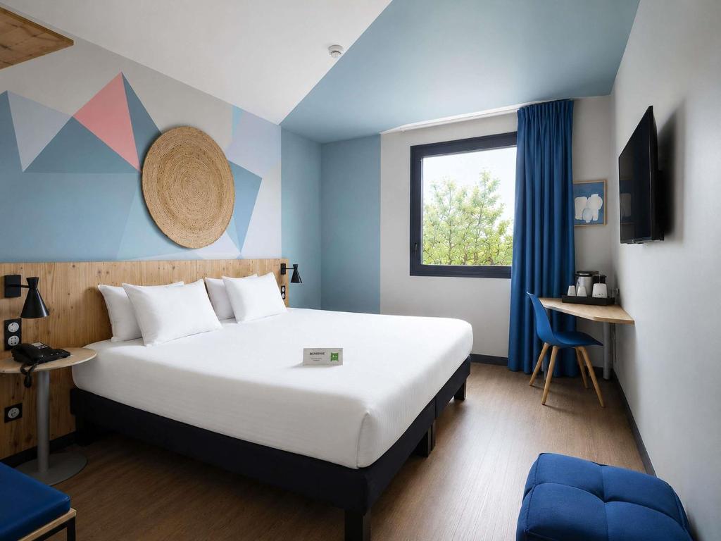 a hotel room with a bed and a window at Ibis Styles Evry Lisses Paris Sud in Courcouronnes