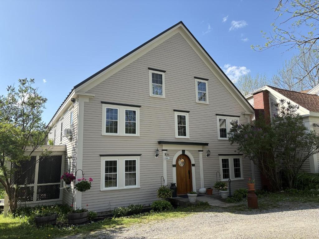 a white house with a brown door at Hawks House Inn in Walpole
