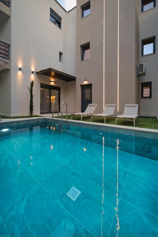 a pool at a hotel with chairs and a building at Sea Salt Skiathos in Skiathos