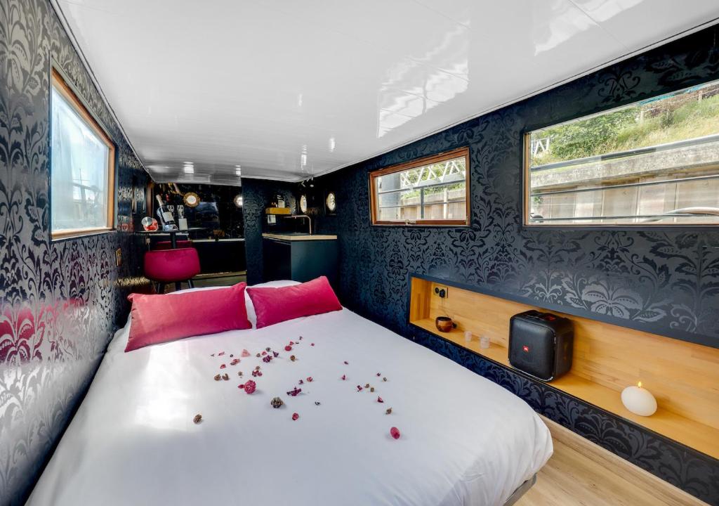 a bedroom with a bed with pink pillows at Love Room sur l'eau & Rooftop in Asnières-sur-Seine