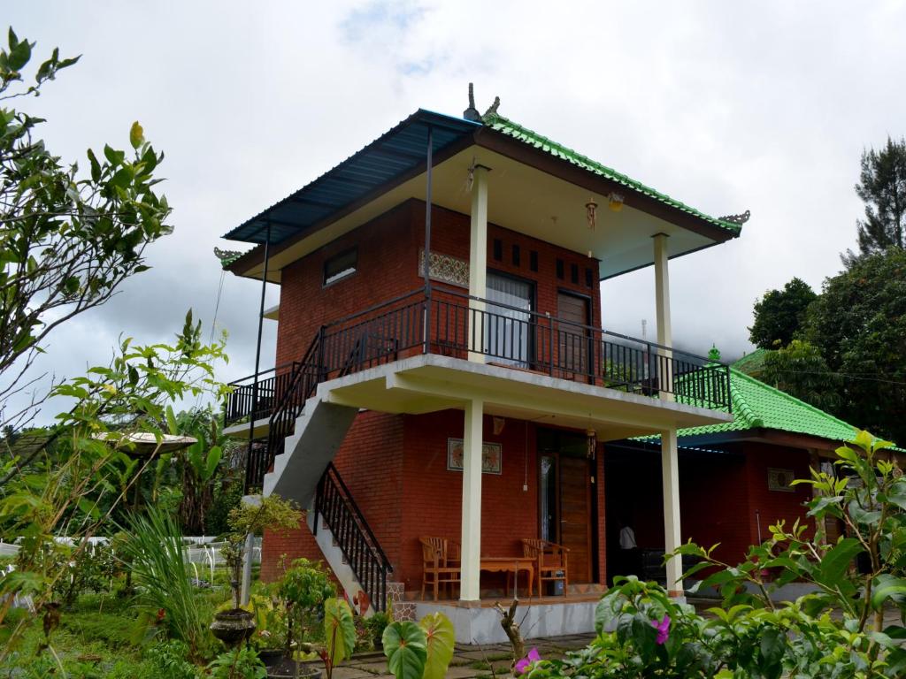 a red brick house with a green roof at Dajan Buyan Homestay in Bedugul