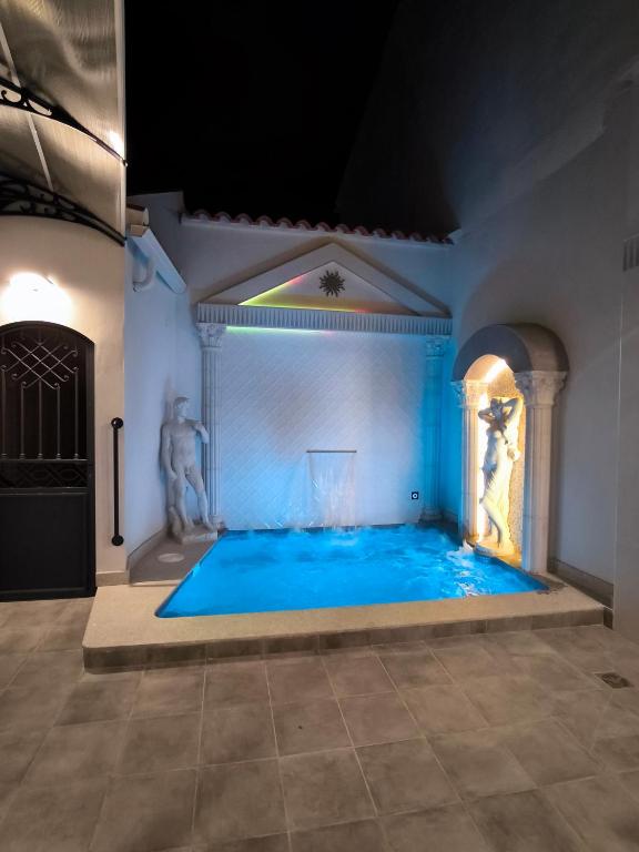 a pool in a room with a statue in the middle at AniCa IV De Cine in Tomelloso
