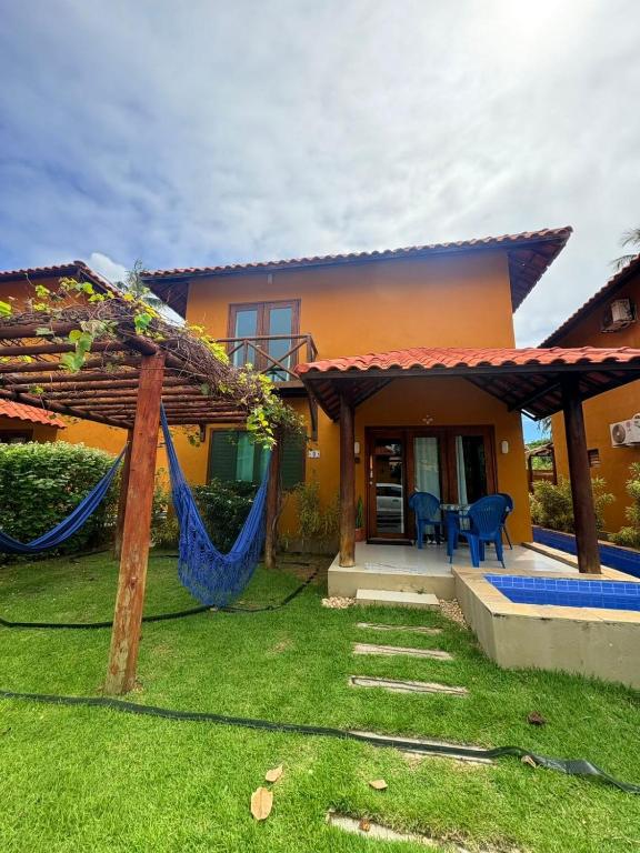 a house with a hammock in the yard at Maruá - Brisa e Sossego em Touros in Touros