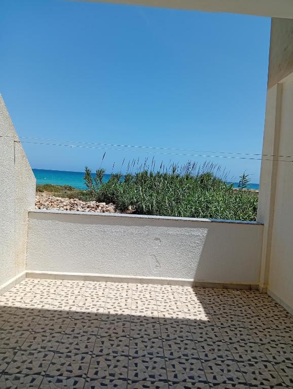 a room with a window with a view of the ocean at B Résidence in Salakta