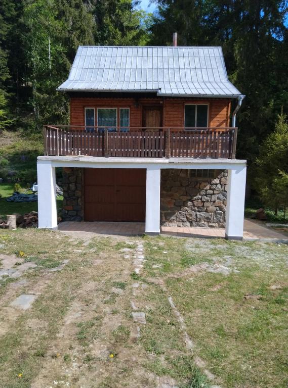 a house with a deck and a garage at Srub v lese in Hrabŭvka