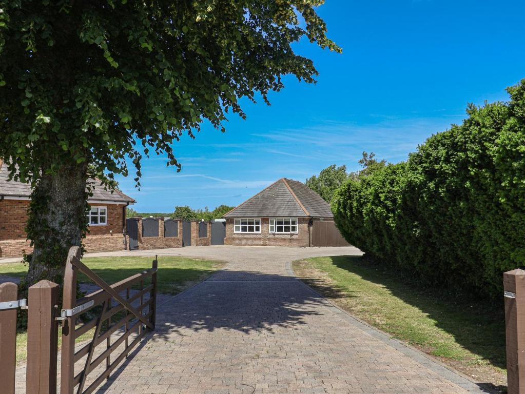 Eine Auffahrt führt zu einem Haus mit einem Zaun in der Unterkunft Frome View in Wareham
