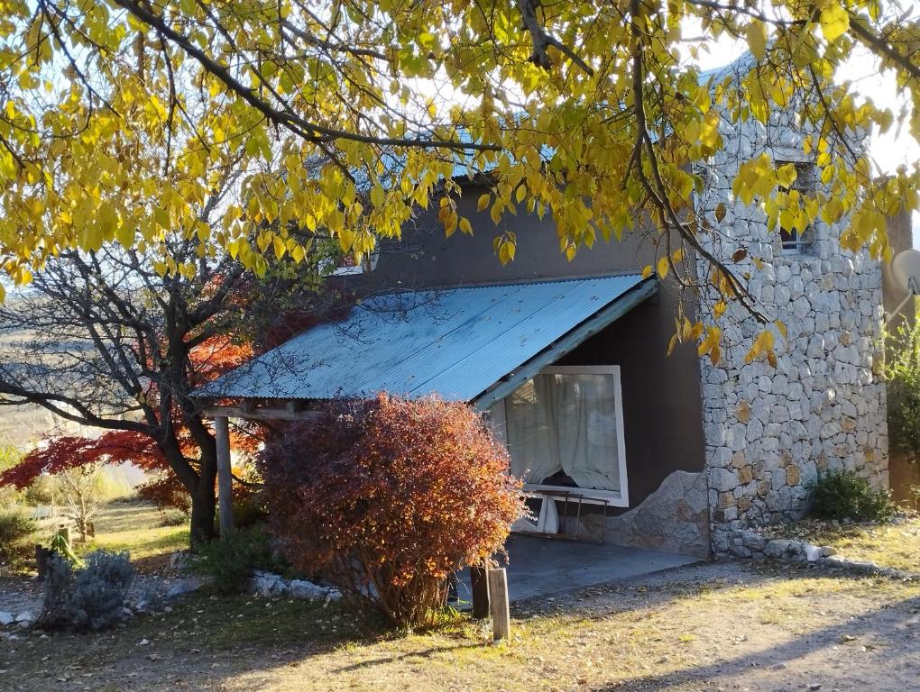 a stone building with a blue roof at Cabaña Kokopelli in Villa Giardino