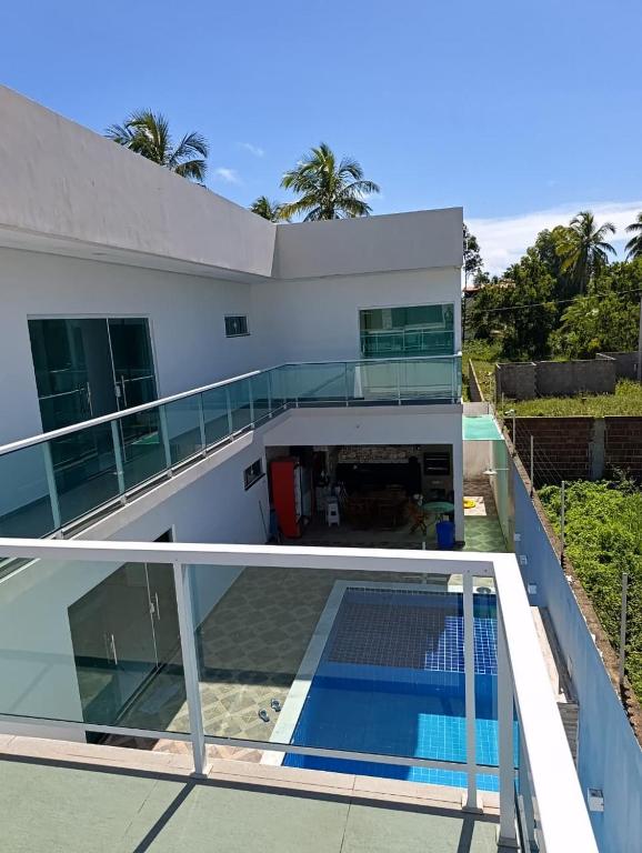 a house with a balcony with a swimming pool at Pousada Natural Hostel in Maragogi