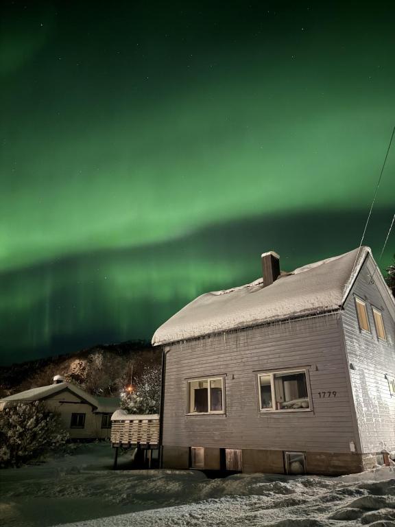 a house with the aurora in the sky at Nordlys Skaland in Senja