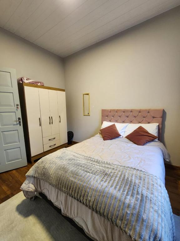 a bedroom with a large bed and a white cabinet at Quarto central em ótima localização in Curitiba