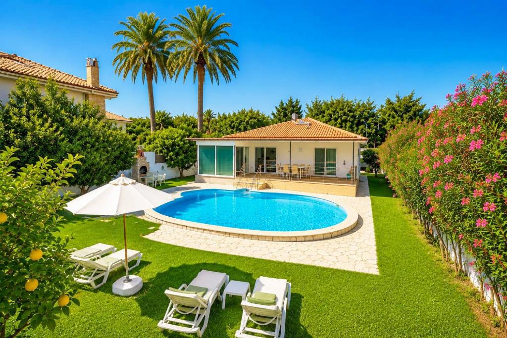 a backyard with a pool and chairs and a house at Villa Sena in Dalyan