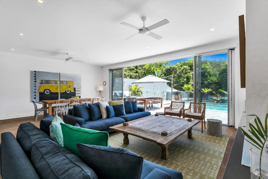 a living room with blue couches and a table at Stonecutters 2 in Byron Bay