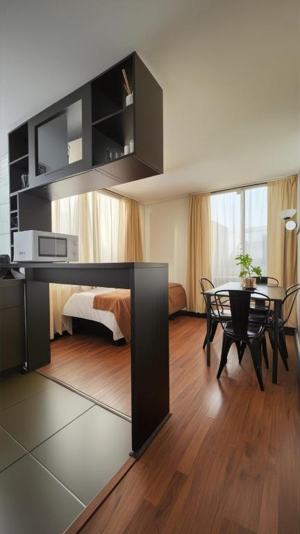 a living room with a table and a dining room at Personal Aparts Bellas Artes in Santiago