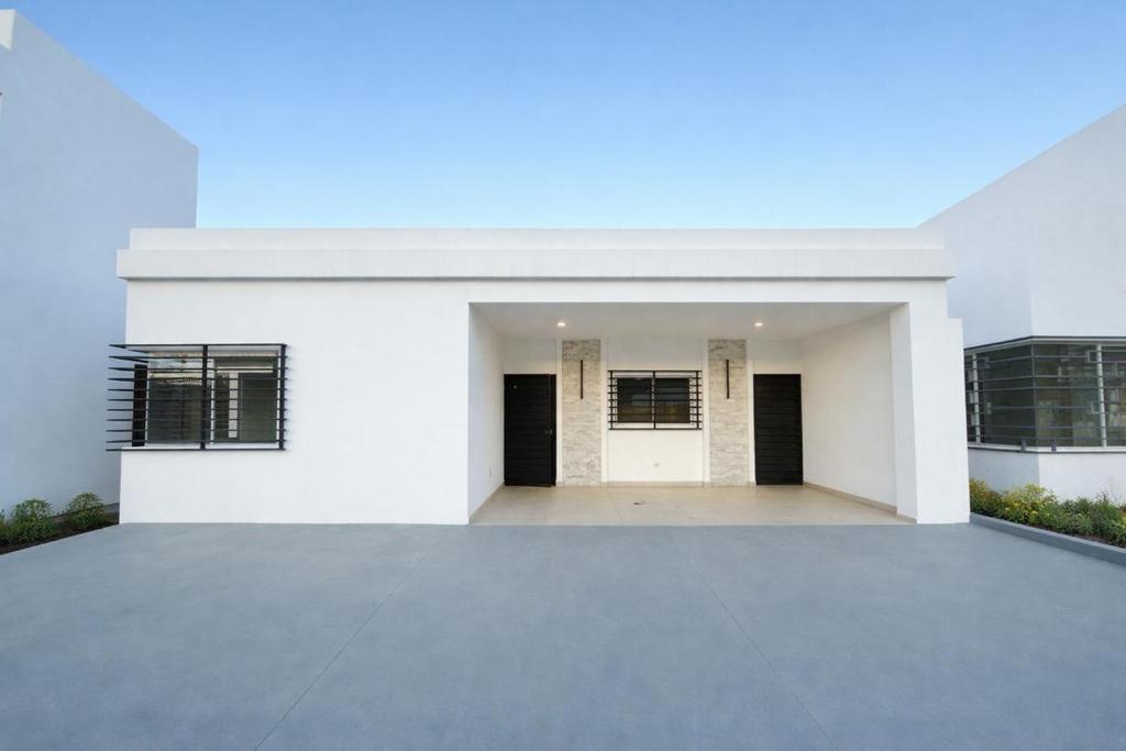 a white house with a large parking lot at Casa Brisas del Sur in San Juan del Sur