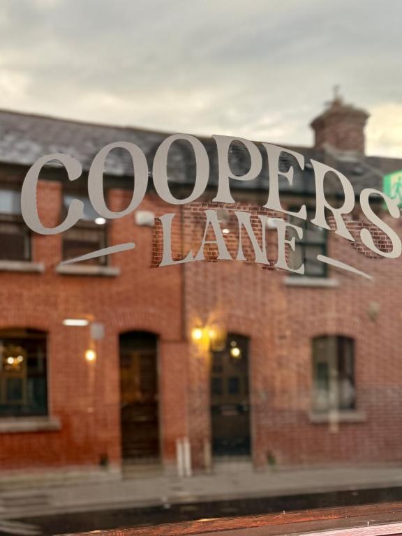 a sign on the side of a brick building at Coopers Lane in Dublin
