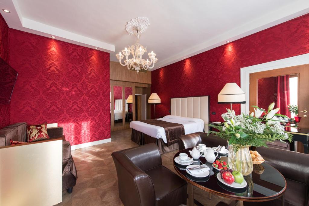 a living room with red walls and a bedroom at Locanda Leon Bianco on the Grand Canal in Venice