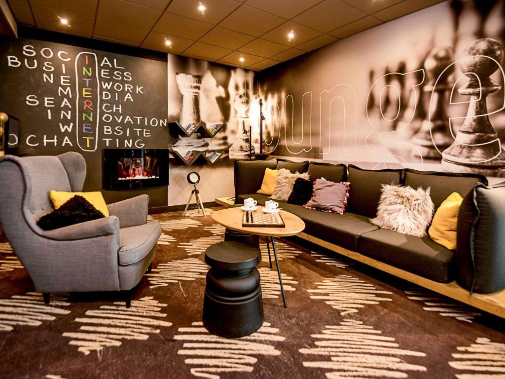 a living room with a couch and two chairs and a table at Ibis Poznan Stare Miasto in Poznań