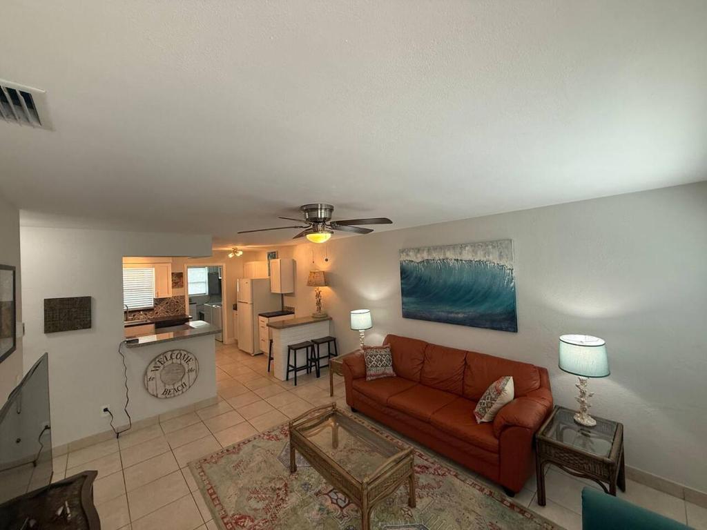 a living room with a couch and a kitchen at Rosewood 1 in Vero Beach