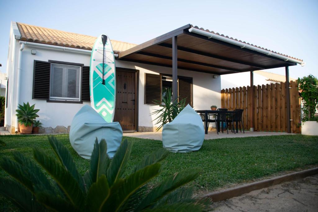 a house with a surfboard in the yard at Casa El Palmar - Playa y Jardín in El Palmar