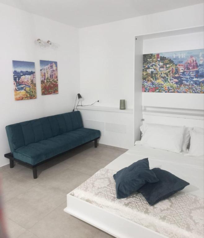a white bedroom with a bed and a couch at Room via Florio in Alcamo