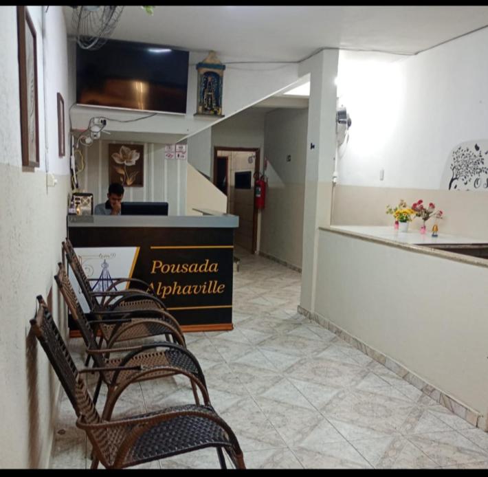 a group of chairs in a restaurant with a counter at Pousada Alphaville in Aparecida