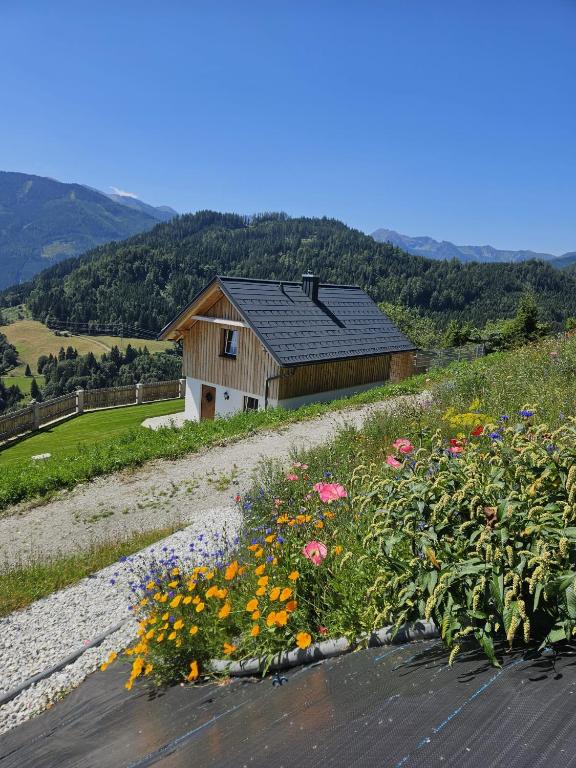 a house on a hill with a field of flowers at Alpenchalet Sonnberg in Kalwang