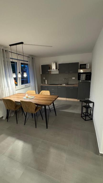 a kitchen with a wooden table and chairs in a room at Ferienwohnung Emerson 2 in Edemissen