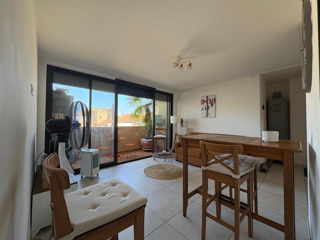 a living room with a desk and a table and chairs at L'appartement du bonheur - Au Cœur des Volcans d'Auvergne sur la Route du Sud in Issoire