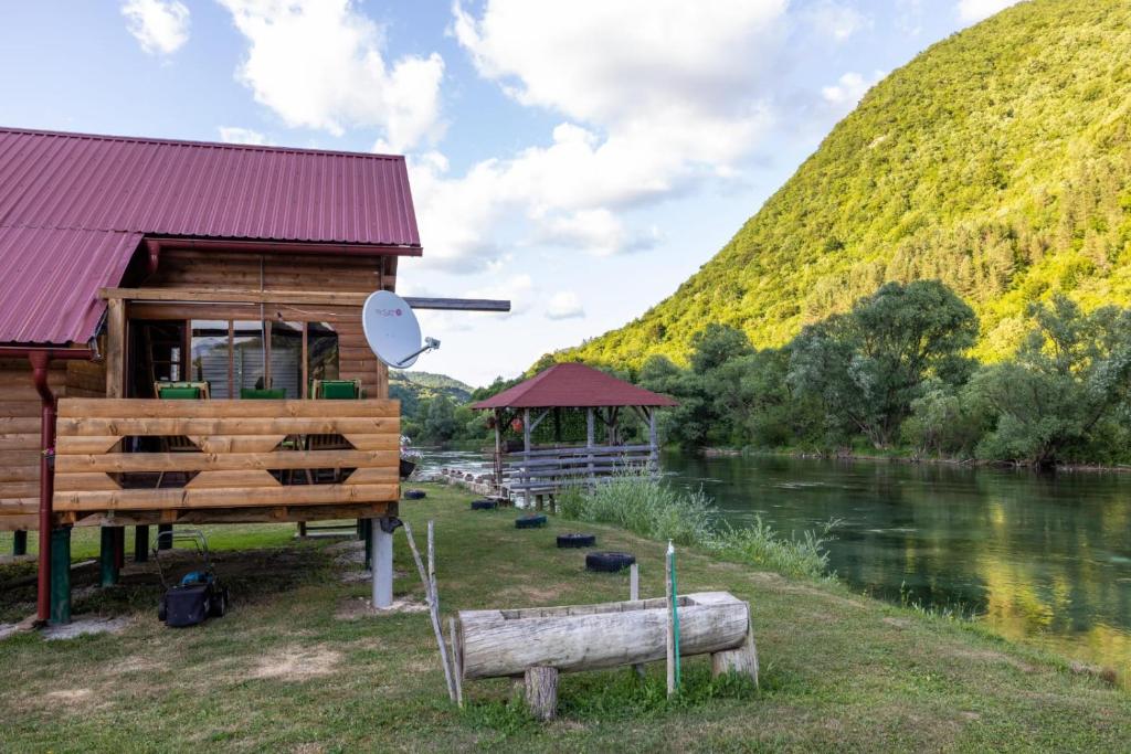 a cabin next to a river with a hill at Vikendica Na Plivi E&M in Šipovo